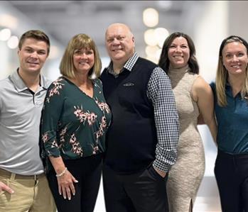 Family of four adults, mother, father with one son and two daughters in group photo